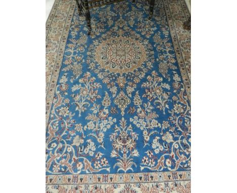 A Persian blue ground Nain carpet, having central medallion on a floral ground, multi-bordered and fringed. L.246cm W.149cm