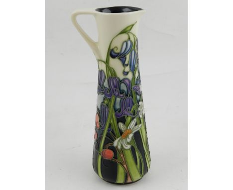 Moorcroft, England. A ceramic water jug, decorated with flowers, bears makers mark C.P., dated 2005. H: 19cm (boxed)