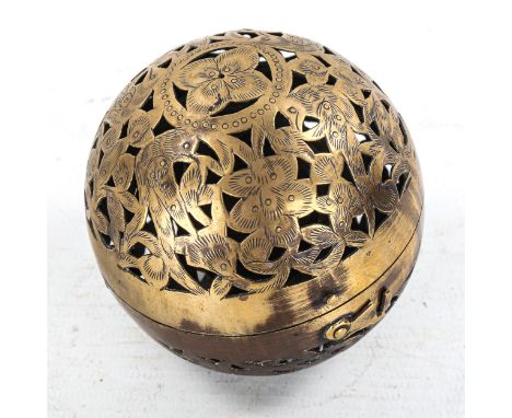 A pierced and engraved brass ball-shaped incense burner, containing a gimballed lamp, diameter 7.5cm 
