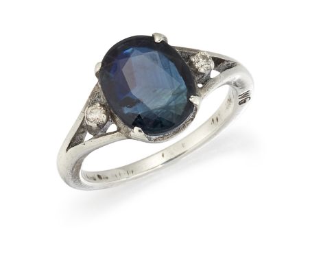 A SAPPHIRE AND DIAMOND RING, the oval sapphire, claw set with a single diamond highlight to either side, in unmarked white me