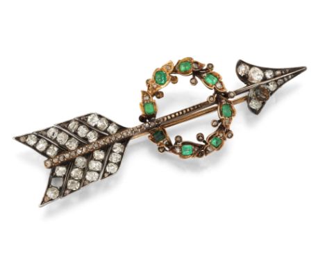 AN EMERALD AND DIAMOND ARROW BROOCH, the arrow with old mine cut diamond head and tail feathers, with a wreath to centre set 