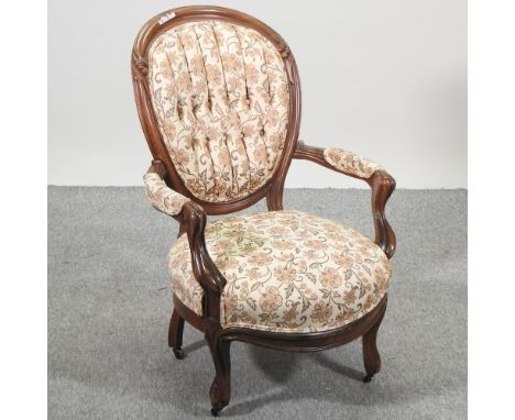 A Victorian carved mahogany and floral upholstered button back show frame armchair