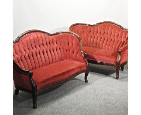 A pair of Victorian style mahogany and red upholstered button back sofas, each 143cm