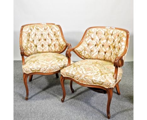 A pair of floral upholstered armchairs, with button backs and scrolled arms