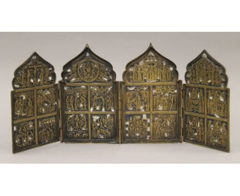 An 18th century or earlier Russian brass and enamel four panel folding icon. 16 cm high.