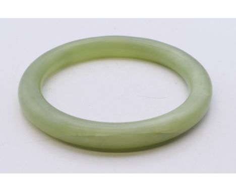 A celadon jade bangle. Approximately 5.5 cm internal diameter.