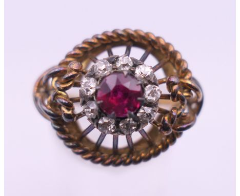 An unmarked gold ruby and diamond cluster ring. Ring size O. 6.1 grammes total weight.