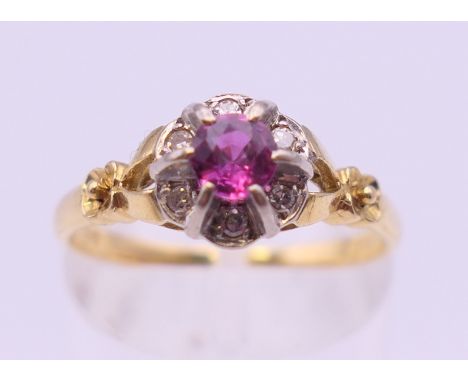 An 18 ct gold ruby and diamond cluster ring. Ring size N/O. 3.3 grammes total weight.