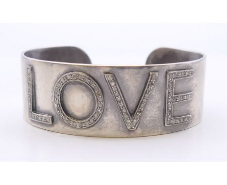 A silver and diamond Love bangle. 6 cm wide. 41.4 grammes total weight. 