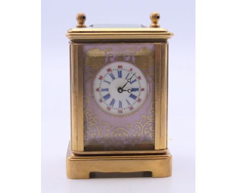 A miniature porcelain mounted carriage clock. 7 cm high. 