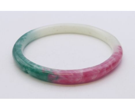 A multi-coloured jade bangle. Approximately 7 cm internal diameter. 