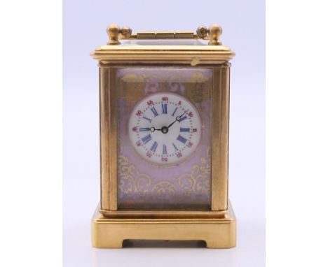 A miniature porcelain mounted carriage clock. 7 cm high. 