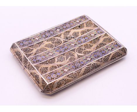 An unmarked white metal filigree cigarette case with enamel decoration. 10 cm wide. 100.6 grammes total weight. 