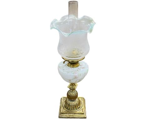A late 19th or early 20th Century oil lamp with frosted frilled glass shade, marbled glass font and a ribbed brass base, 60cm