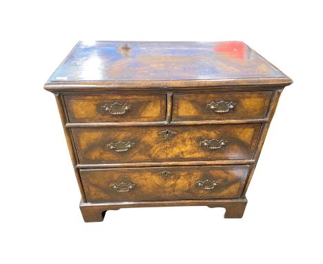 A 18th Century and later chest with two short and two long drawers, finished with walnut and cross banded veneer raised on br