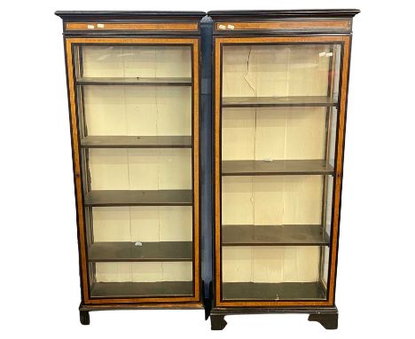 A pair of Victorian ebonised and inlaid narrow display cabinets with glazed doors, fitted shelves and bracket feet, 58cm wide