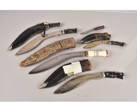 A Middle Eastern Bone Handled Kukri knife and scabbard, together with a group of other kukri knives, of various sizes and con