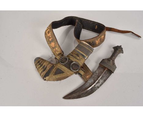 A Middle Eastern Khanjar, having white metal handle with raised design, the curved blade with central spine, complete with sc