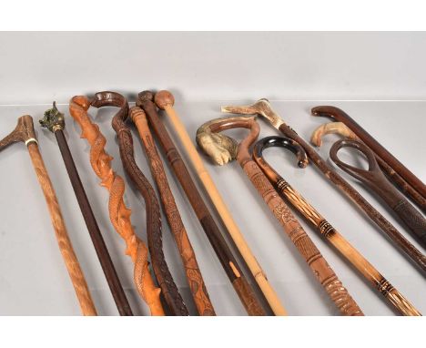 A collection of walking sticks and canes, including ethnic examples, one in the form of a cobra, one having a bust top, antle