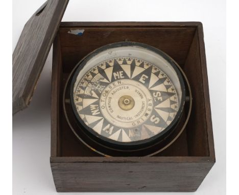 A  6 1/2 inch dry card compass by  O T Olsen, Grimsby:, the black and white card in a glazed brass case on a  gimbal mount in