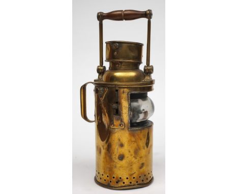 A  19th century brass signal lamp:, unsigned, turned wooden handle over chimney and cylindrical body with clear glass lens, w