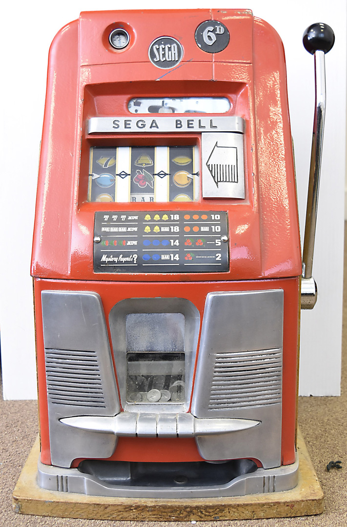 A Sega Bell fruit machine, red body and oak framed, with a quantity of ...