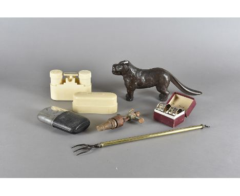 A collection of miscellaneous items, including a telescopic toasting fork, a cast iron dog nut cracker, a box of razors and o