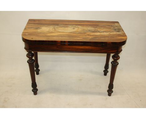 A William IV rosewood games table, having swivel rectangular top with green baize playing surface supported on four tapered a