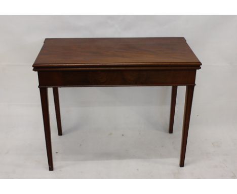 A 19th Century mahogany folding card table, with brass hinges, baize playing surface, on tapering reeded legs, 92 cm x 74 cm 