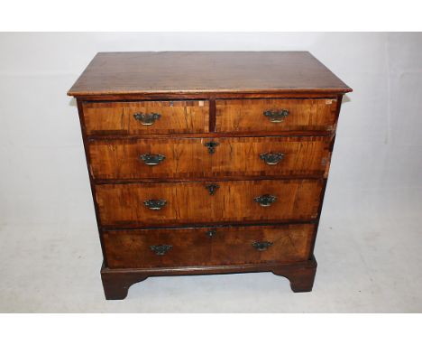 A Georgian flat fronted chest of drawers, walnut veneered with mahogany crossbanding, two short over three graduated long dra