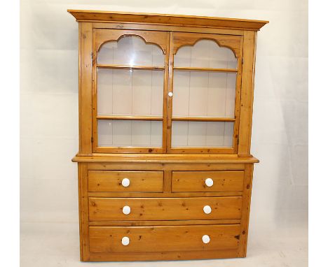 An Edwardian pine dresser, having glazed top section with double doors to three shelf interior over two short and two long dr