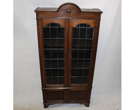 An Edwardian glazed oak bookcase, with panel doors to base, bracket feet, 94 cm x 197 cm high x 31 cm deep