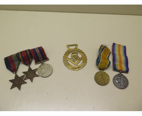 Two WWI medals to T-4449 Pte SW Holloway The Queens R, three unnamed WWII medals and a Churchill brass 