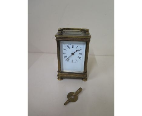 A brass carriage clock with key - Height 13cm - one small chip to glass otherwise good 