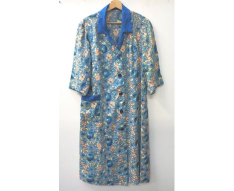 CHINESE EMBROIDERED SILK AND COTTON LONG JACKETwith a pale blue ground decorated with flowers and a Royal blue collar and poc
