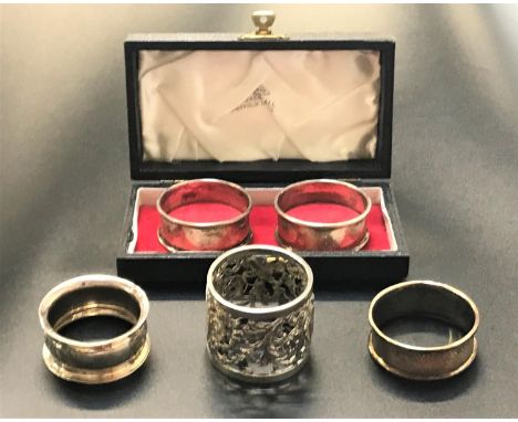 FIVE SILVER NAPKIN RINGScomprising a boxed pair by Walker and Hall, Birmingham 1960; a George V pierced and scroll decorated 