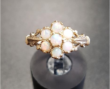 OPAL CLUSTER RINGthe round cabochon opals flanked by motif decorated shoulders, on nine carat gold shank, ring size M 