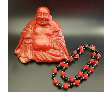 CHINESE CINNABAR LACQUER BUDDHAseated holding a scroll and beads, 10.5cm high; together with a Chinese bead necklace with car