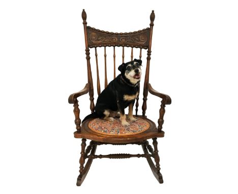 AMERICAN OAK AND ELM ROCKING CHAIRwith a shaped and carved top rail above a shaped stick back with outswept arms above a shap