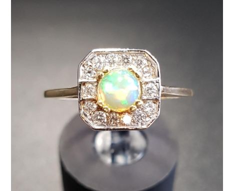 OPAL AND DIAMOND CLUSTER DRESS RINGthe central round cabochon opal in fourteen diamond surround, on eighteen carat gold shank