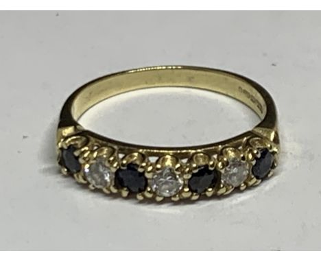 A 9 CARAT YELLOW GOLD RING WITH FOUR SAPPHIRES AND THREE CUBIC ZIROPNIAS IN LINE SIZE Q/R