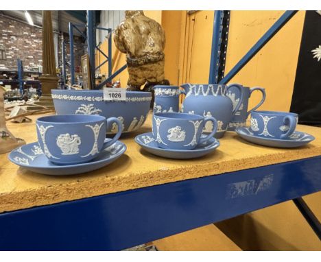 VARIOUS LARGE ITEMS OF BLUE AND WHITE WEDGWOOD JASPERWARE TO INCLUDE A BOWL, JUGS AND THREE CUPS AND SAUCERS