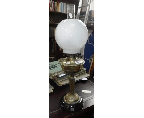 AN INDIAN BRASS TRAY TOP TABLE, with folding wooden stand and an Edwardian brass oil lamp with black ceramic foot