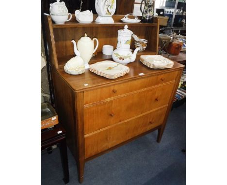 A MID-20TH CENTURY PALE WOOD SIDE CABINET with three drawers lift-up top flap and raised back shelf, on tapering legs, with l