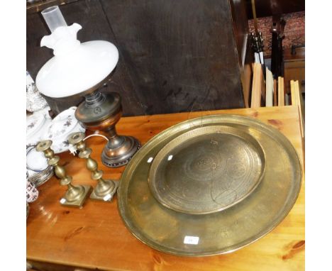 AN EDWARDIAN BRASS OIL LAMP (converted to electricity), two Indian brass trays and a pair of candlesticks