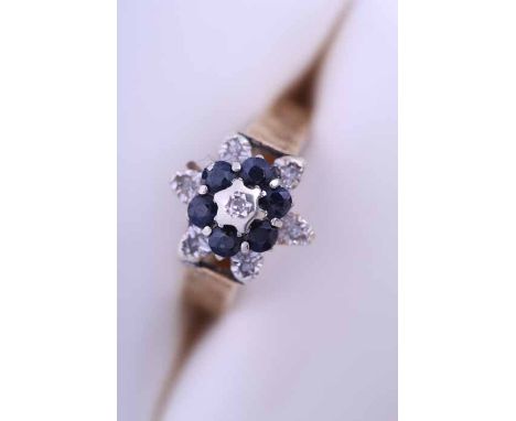 DIAMOND AND SAPPHIRE RING
of floral form, set centrally with an illusion set diamond, surrounded by rows of sapphires and dia