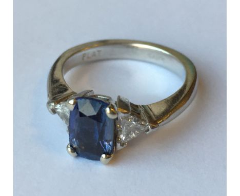 SAPPHIRE AND DIAMOND THREE STONE RING the central oval sapphire approximately 2.03 carat, flanked by two trilliant cut diamon