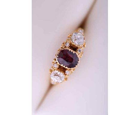 GARNET AND DIAMOND THREE STONE RING
the central oval garnet measuring approximately 6.29mm x 4.99mm, flanked by two old cut d