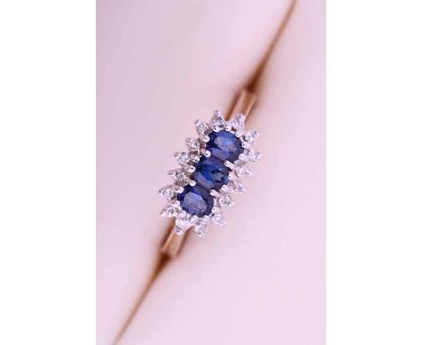 THREE STONE SAPPHIRE AND DIAMOND CLUSTER RING
with three oval sapphires, surrounded by a cluster of brilliant cut diamonds, h