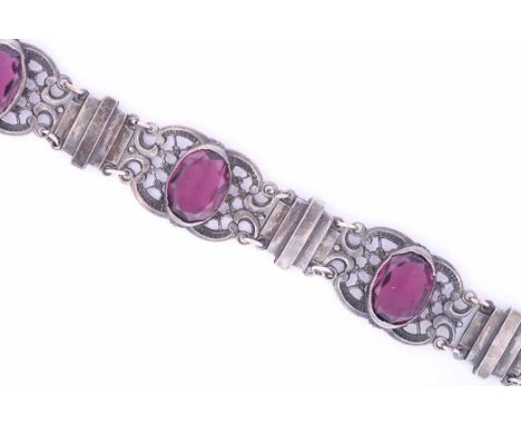 SILVER AMETHYST BRACELET
of pierced scrolling form, set with four oval amethysts, unmarked, 180mm long